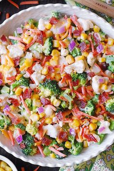 a bowl filled with corn and broccoli on top of a table