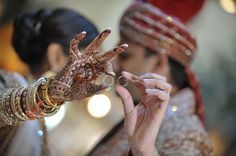 a woman is holding up her hands with henna on their fingers and wearing jewelry