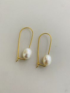 FLOATING THROUGH LIFE WHAT IT IS: A fresh water pearl elegantly dangling on a gold vermeil wire. WHY IT'S SPECIAL: These chic and modern dangle earrings feature a lustrous white freshwater pearl that seems to float below your ears. Freshwater pearls are unique and one of a kind so sizes and shapes will vary, which makes them extra special. GOODTO KNOW: Gold VermeilFreshwater PearlWire Drop Length: 3/4" Elegant Gold Plated Pearl Earrings With Ear Wire, Gold Pearl Earrings With 14k Ear Wire, Minimalist Wire Wrapped Pearl Drop Earrings, Handmade Delicate 14k Gold-filled Pearl Earrings, Gold Wire Wrapped 14k Gold-filled Pearl Earrings, Fresh Water Pearl, White Freshwater Pearl, Rock A, Gold Wire