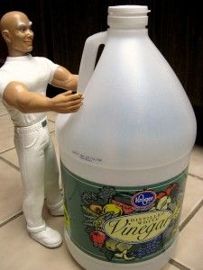 a plastic man standing next to a gallon of liquid