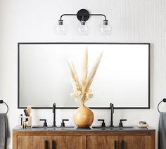 a bathroom vanity with two sinks and a large mirror above it, along with towels hanging on the wall