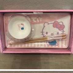 a hello kitty dinner set with chopsticks, bowl and plate in its box