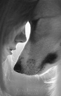 a woman and her dog are looking at each other's eyes in black and white