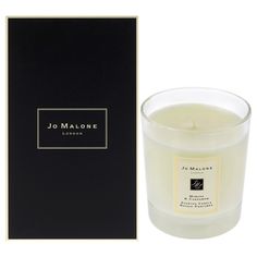 a candle that is next to a black box with the label jo malone london on it