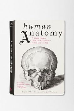 a book about human anatomy on a white surface with black lettering and an image of a skull