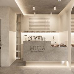 the front desk of muka dessert house in an empty room with white walls and concrete flooring