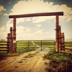 an open gate leading to a dirt road