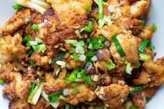 a white plate topped with fried food and veggies on top of each other