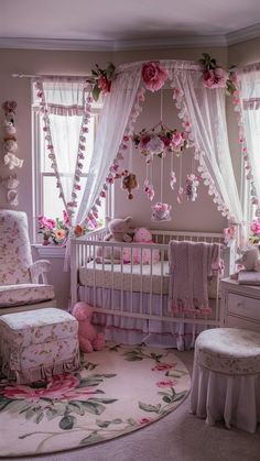 a baby's room decorated in pink and white with flowers hanging from the ceiling