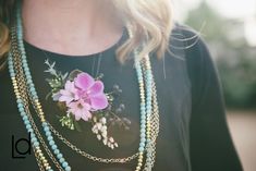 a woman wearing a necklace with flowers on it