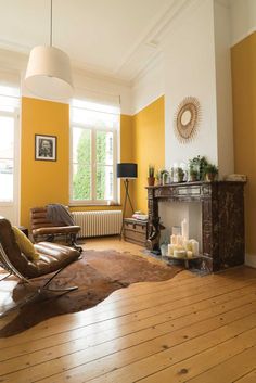 a living room filled with furniture and a fire place next to a wall mounted heater