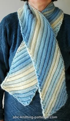 a woman wearing a knitted scarf in blue, white and grey colors with stripes