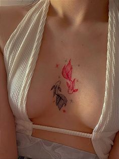 a woman's chest with a butterfly tattoo on her left side, and a pink flower in the center