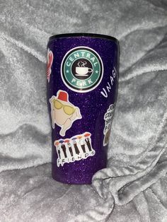 a purple starbucks cup with stickers on it