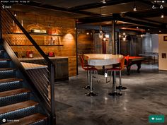 a room with some chairs and a table in front of a stair case that leads up to the second floor