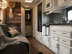 the interior of an rv with white cabinets and wood flooring