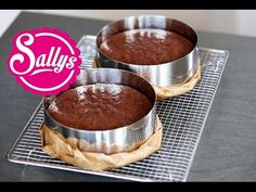 two pie tins sitting on top of a cooling rack filled with chocolate cake batter