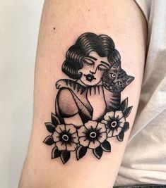 a woman with a cat on her shoulder and flowers around her arm is shown in black ink