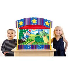 two children standing in front of a wooden toy train with animals and stars on it