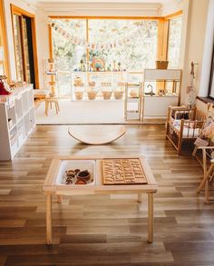 a living room filled with lots of furniture and decor on top of hard wood flooring