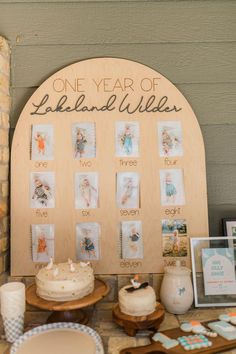 a table topped with cakes and desserts on top of a wooden plaque that says one year of lakeland willie