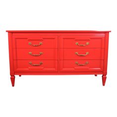 a red dresser with gold handles and drawers