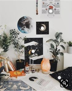 a room with plants, books and pictures on the wall next to a computer desk