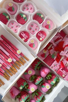 strawberry shaped desserts and strawberries are displayed in boxes