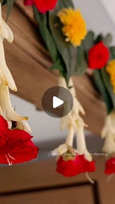 red and yellow flowers hanging from a wooden bench