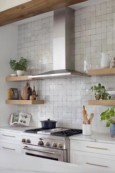 a stove top oven sitting inside of a kitchen next to wooden shelves filled with pots and pans