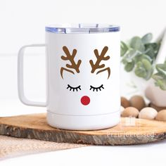 a white coffee mug with reindeer's face painted on it