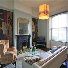 a living room filled with furniture and a fire place in front of a painting on the wall