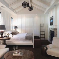 a bedroom with white walls and wood floors