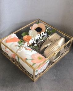 a pair of gold shoes sitting inside of a glass box on top of a table