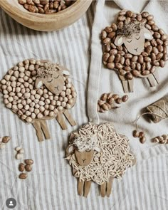 three sheep made out of wooden sticks and nuts on top of a table with other items