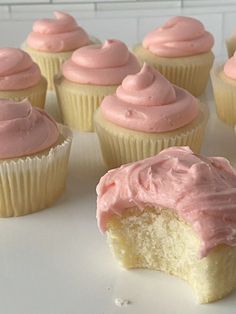 cupcakes with pink frosting sitting on a white plate