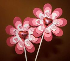 two heart shaped lollipops on top of each other in front of a brown background