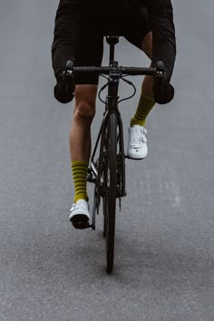 a man riding a bike down a street with his feet on the handlebars