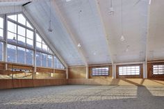 an empty room with large windows and wooden paneling