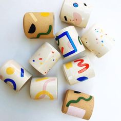 several ceramic blocks with different shapes and colors on them, sitting on a white surface