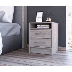 a night stand with two drawers and a lamp next to it on a wooden floor