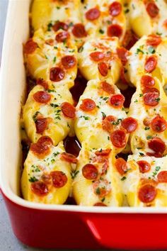 pepperoni and cheese stuffed shells in a red casserole dish, ready to be eaten