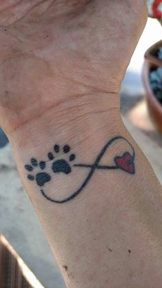 a person with a dog paw tattoo on their wrist