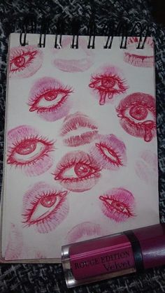 a notebook with lipstick on it next to a lip balm bottle and pencils