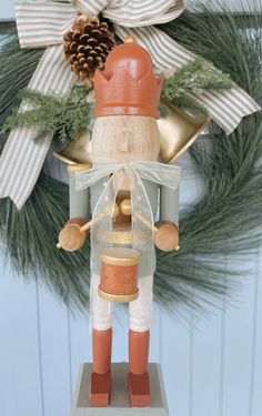 a wooden nutcracker ornament on top of a christmas wreath