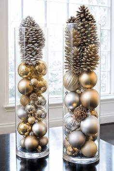 two clear vases filled with ornaments on top of a table next to a window