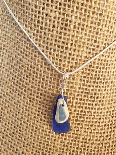 a necklace with a blue and white bird on it