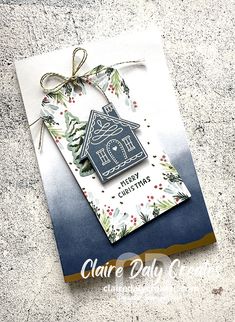 a card with a house on it and a ribbon tied around the edge that says merry christmas