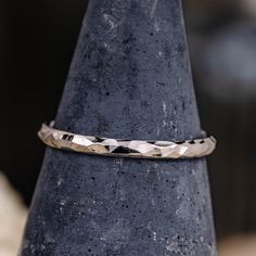 a silver ring sitting on top of a black vase