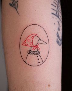 a person with a tattoo on their arm that has a bird in a snow globe